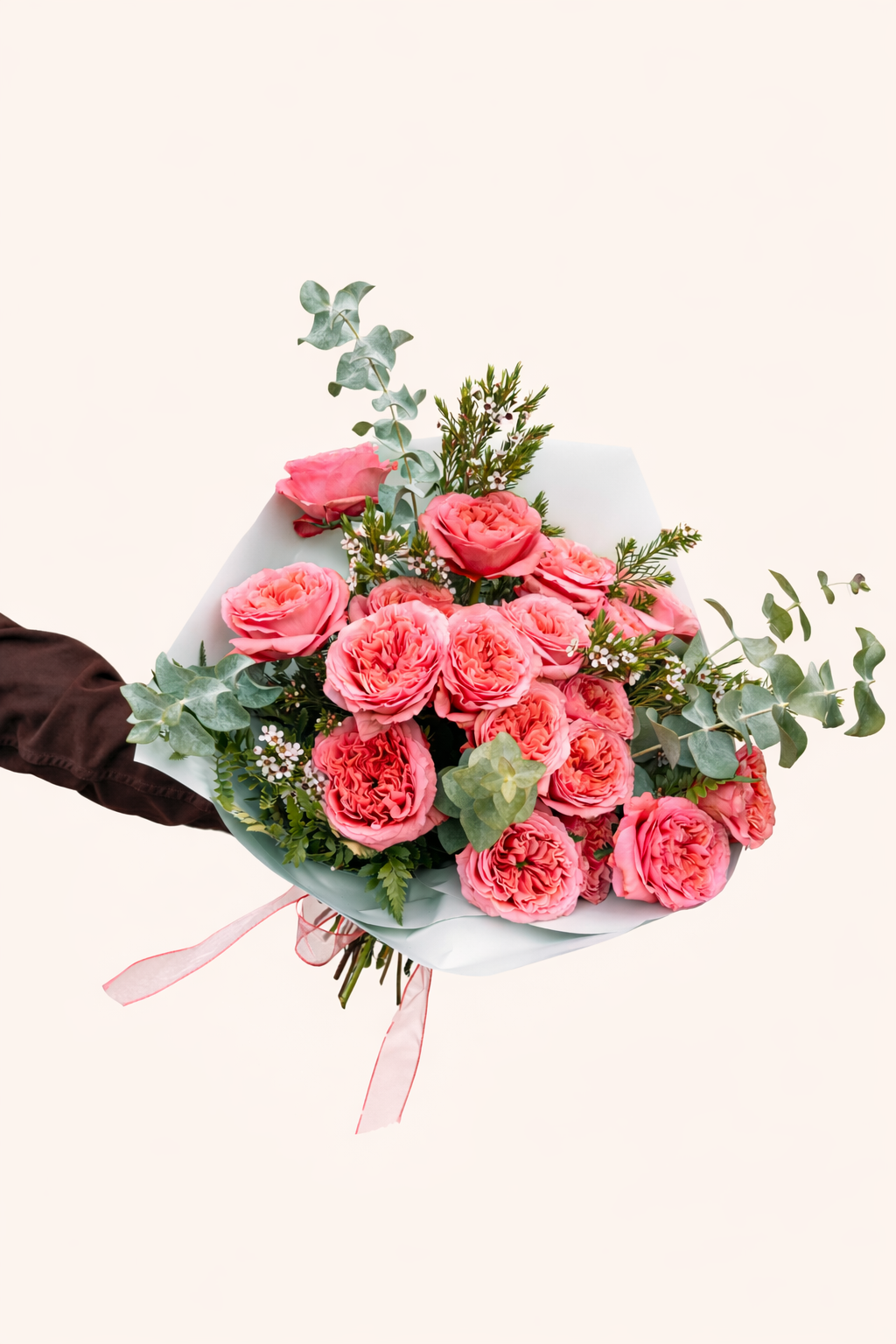 Bouquet of pink roses with greenery on a light background