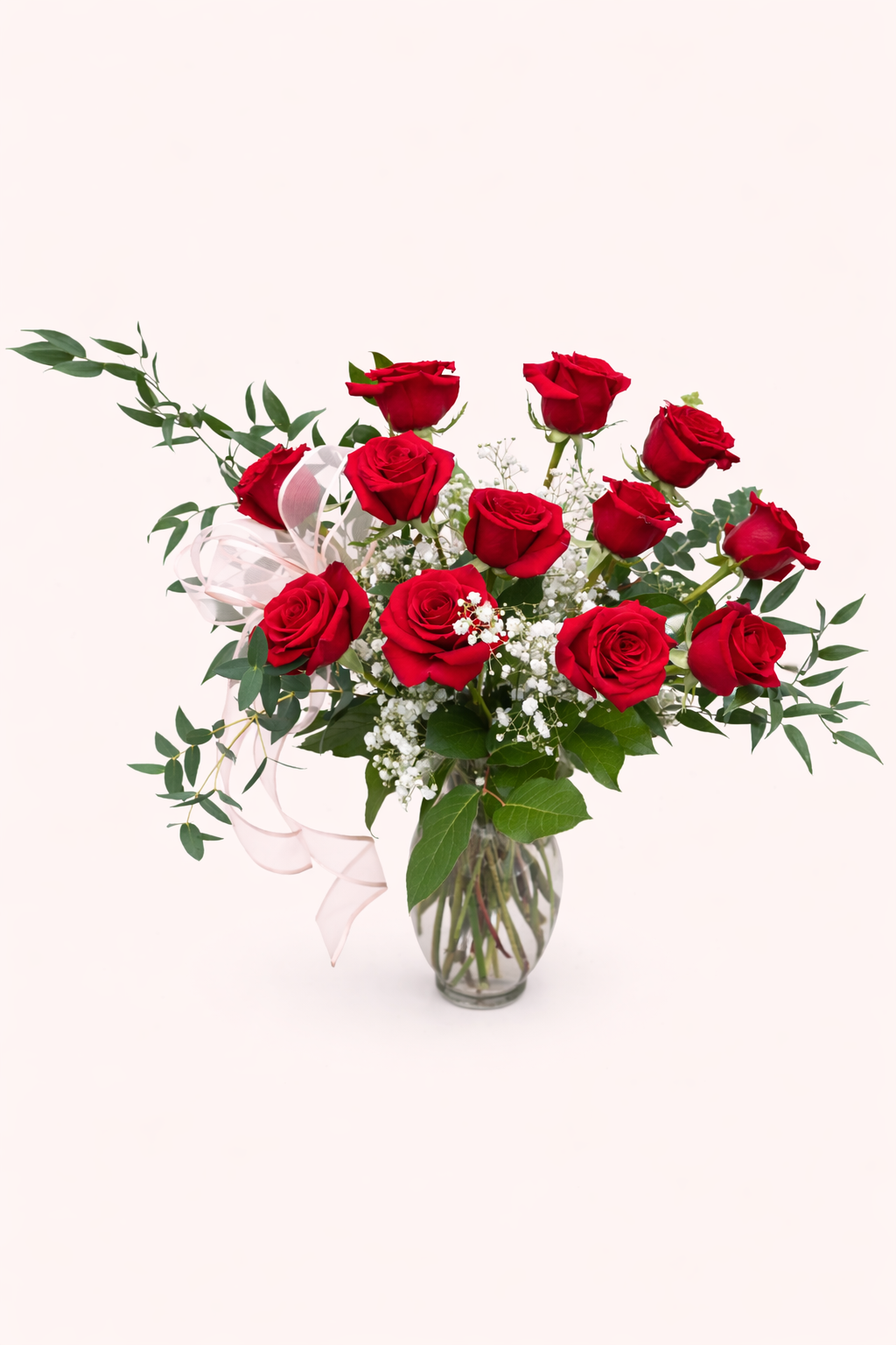 Bouquet of red roses in a clear vase on a white background