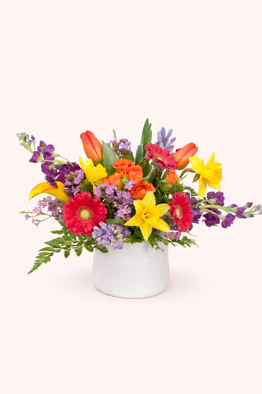 Colorful flower arrangement in a white vase on a white background